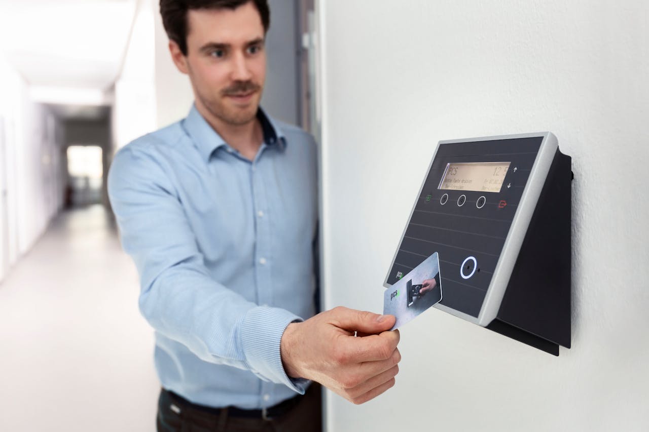 our-journey-01 Professional man using access card on wall reader in office setting.