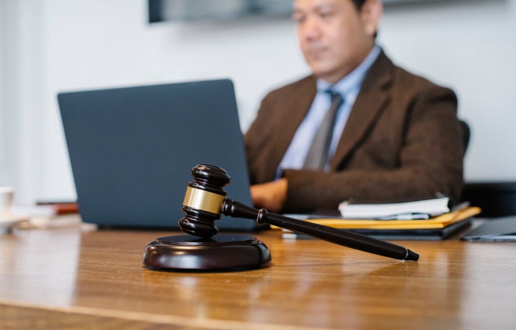 Mastering the First Impression: Your intriguing post title goes here Crop concentrated Asian male judge in formal clothes sitting using modern netbook while working in law office